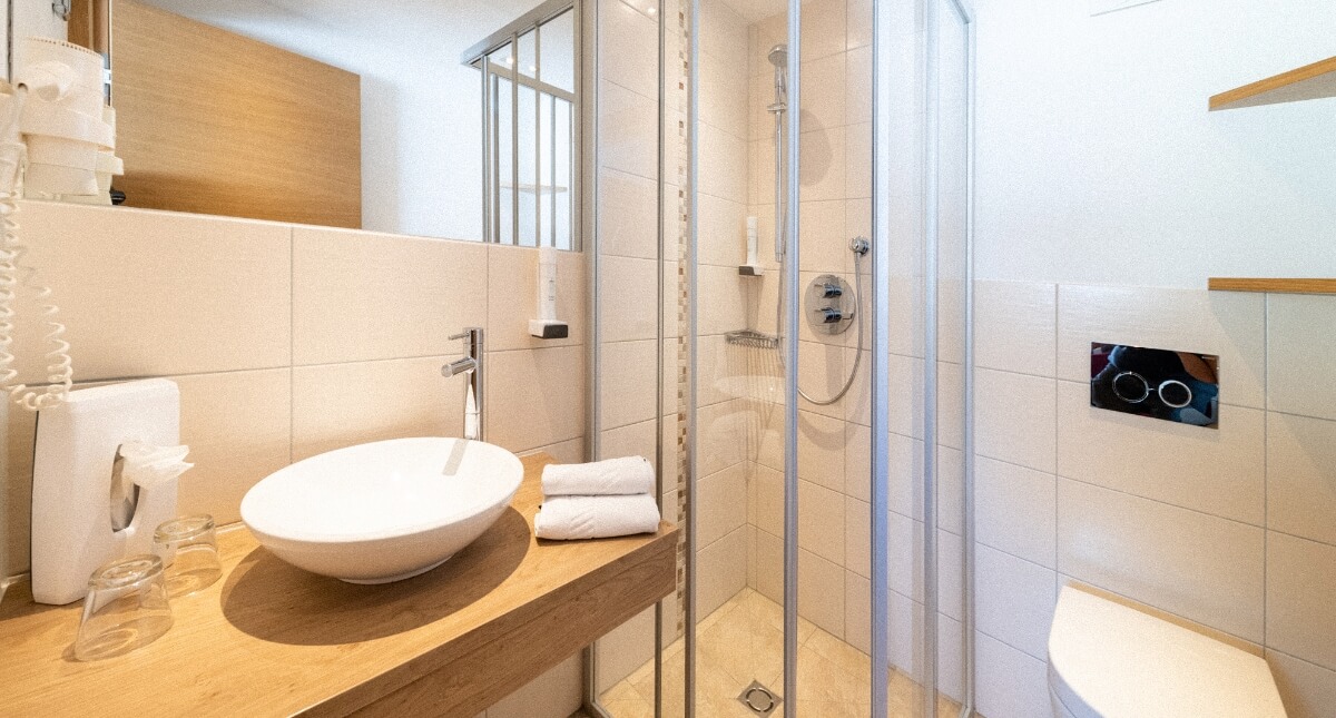 Badezimmer im Hotel mit Waschbecken, Dusche & Toilette