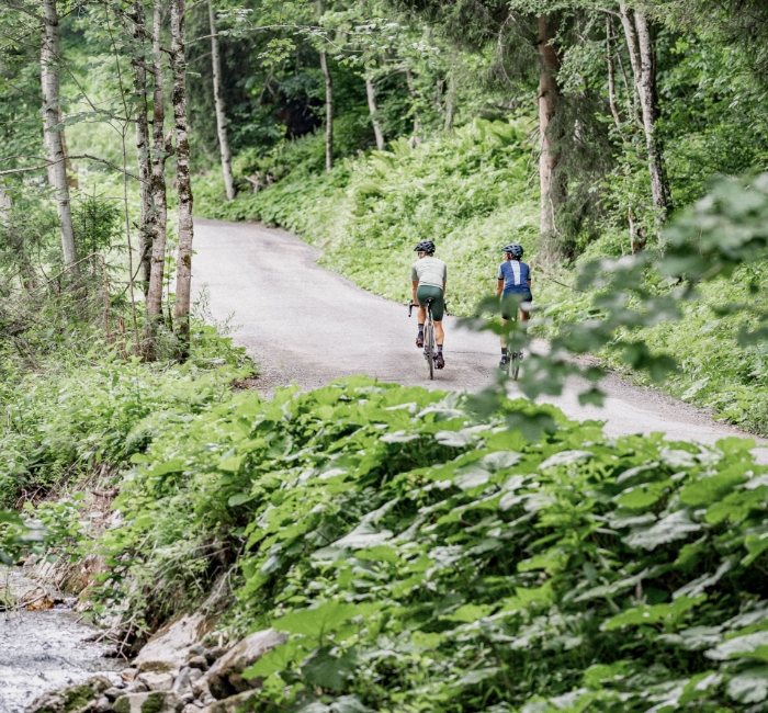 Zwei Radfahrer auf einem Radweg im Wald in Saalfelden
